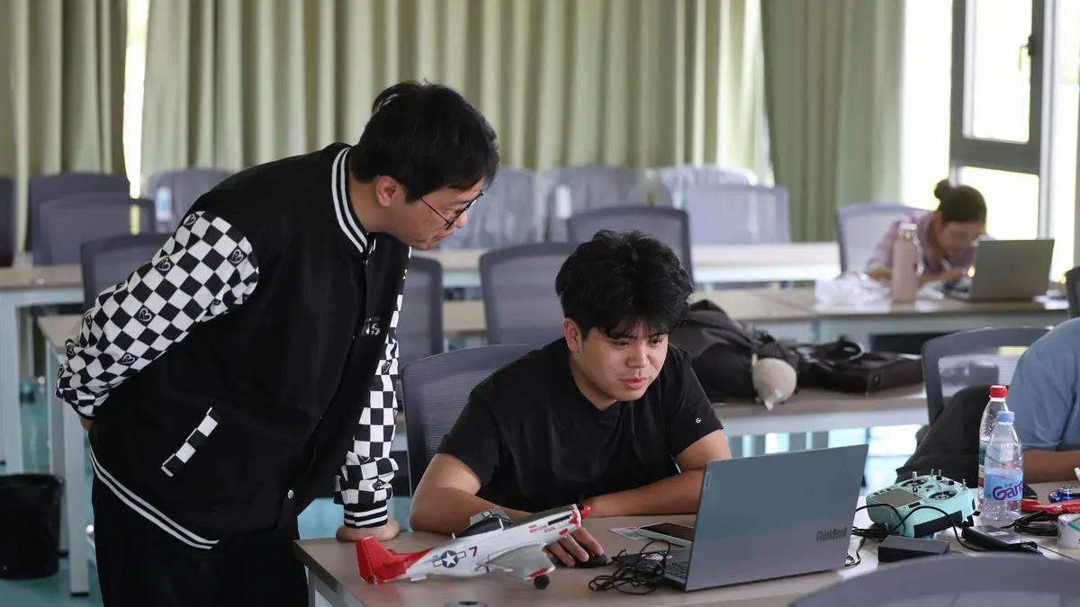 教练在电脑旁指导零基础学员进行模拟训练