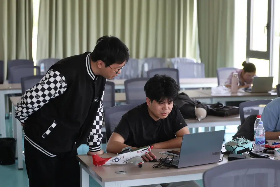 教练正在指导学员使用飞行模拟系统